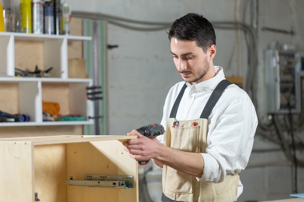 Möbelfabrik, Kleinunternehmen und Personenkonzept - Junge Arbeiter arbeiten in einer Fabrik zur Herstellung von Möbeln.