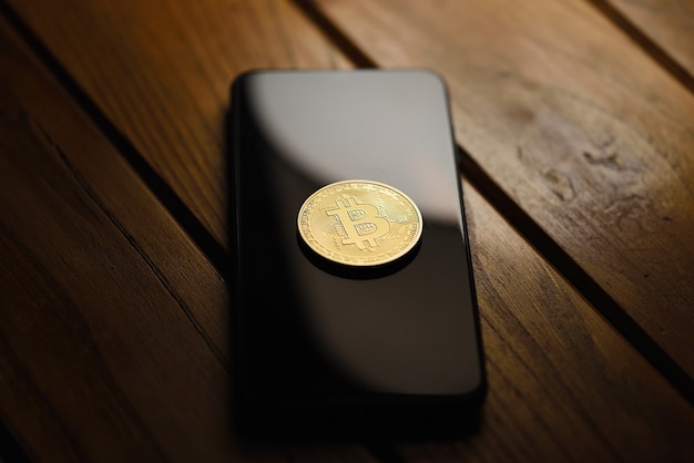 Moeda bitcoin na tela do celular, conceito de ganhar dinheiro em casa