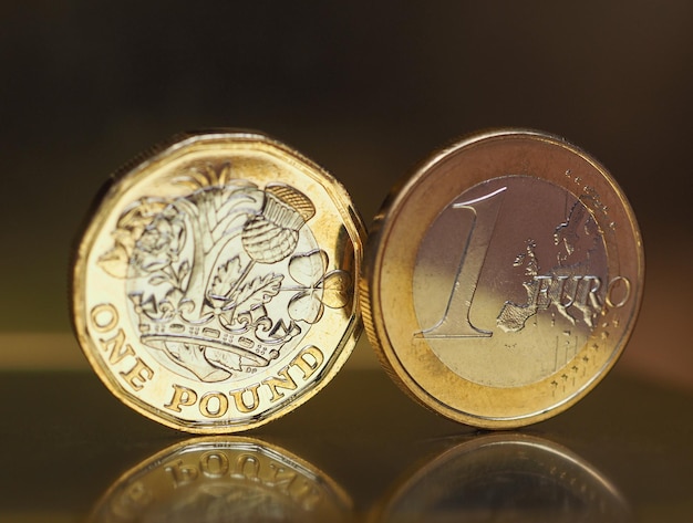 Foto moeda de 1 libra e 1 euro sobre fundo de metal