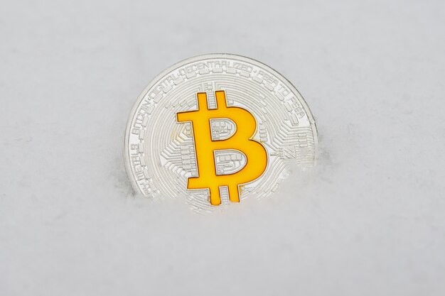 Moeda de bitcoin criptomoeda em uma neve branca