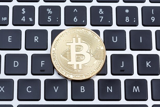 Moeda de bitcoin de ouro de moeda digital no teclado de computador branco