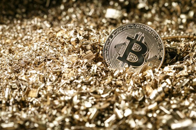 Moeda de metal dourada como versão simbólica do Bitcoin em um fundo de aparas de metal. Criptomoeda e novo conceito de sistema de pagamento digital.