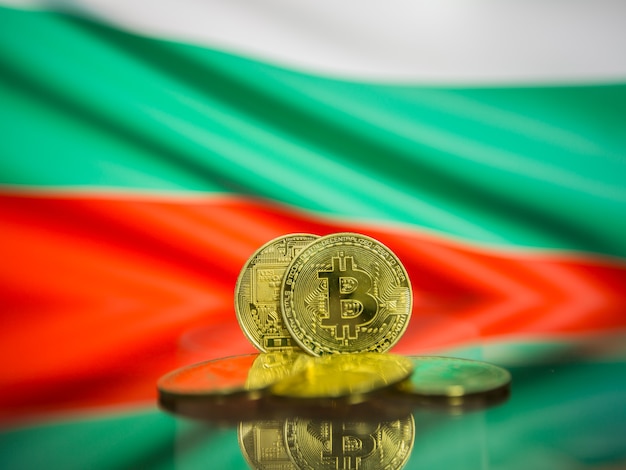 Moeda de ouro Bitcoin e bandeira desfocada do fundo da Bulgária. Conceito de criptomoeda virtual.