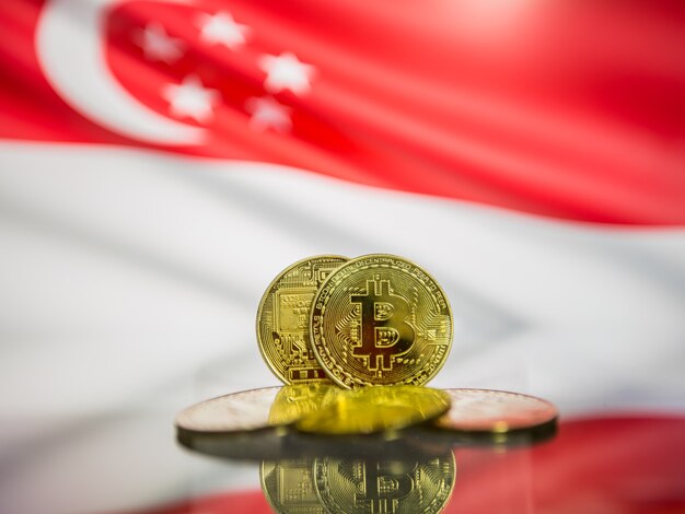 Moeda de ouro de Bitcoin e bandeira desfocada de fundo de Cingapura. Conceito de criptomoeda virtual.