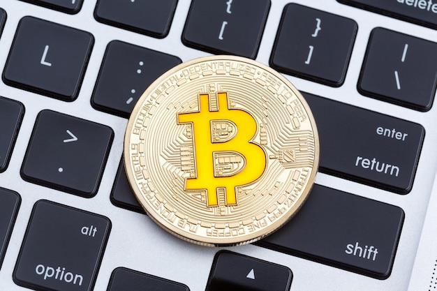 Moeda de ouro de criptomoeda bitcoin dourada no teclado do computador