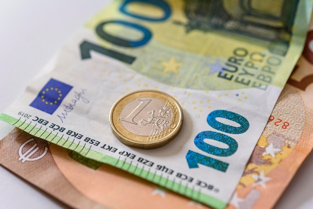 Foto moeda de um euro fechada em notas de euro moeda da união europeia