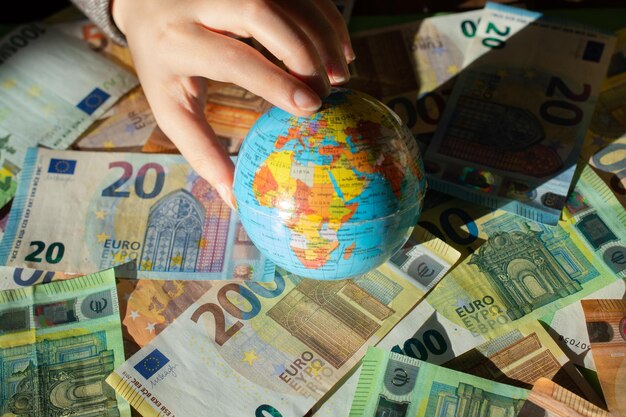 Moeda Euro da União Europeia e globo modelo na mão Contexto financeiro