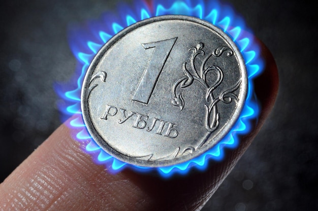 Moeda russa na denominação de um rublexAlie no dedo closeup fotomontagem queimando moeda