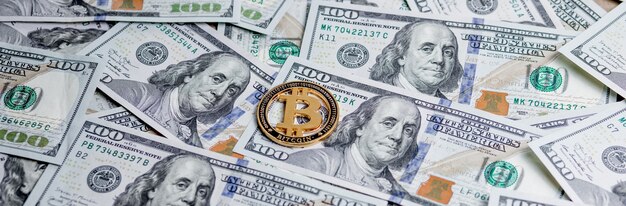 Moeda simbólica de ouro Bitcoin em cédulas de cem dólares Troque dinheiro de bitcoin por um dólar Criptomoeda em notas de dólar americano Método de pagamento digital moderno