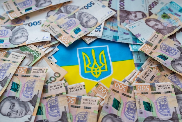 Moeda ucraniana hryvnia no contexto da bandeira ucraniana Assistência estatal aos cidadãos em conexão com a guerra na Ucrânia