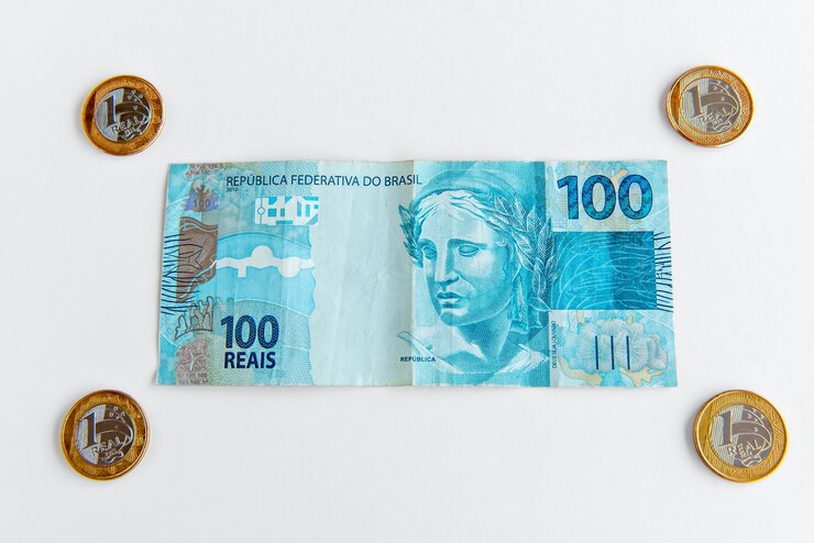 Foto moedas brasileiras e nota brasileira de 100 reais dinheiro real brasileiro em fundo branco