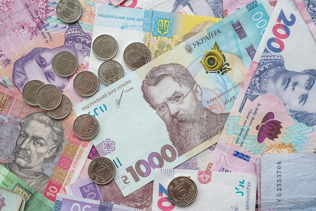 Moedas de dinheiro da Ucrânia sobre fundo misto de notas de hryvnia