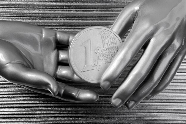 Moedas de euro de prata nas mãos do robô futurista