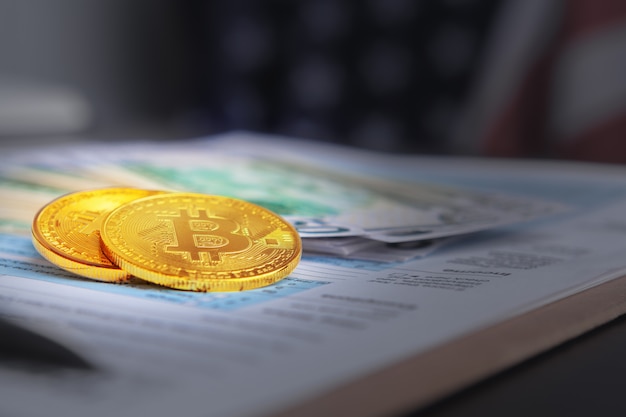 Foto moedas de ouro bitcoin em dólares americanos close-up. moeda criptográfica eletrônica