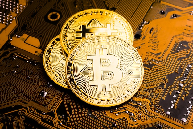 Moedas de ouro com o símbolo de bitcoin na placa principal.