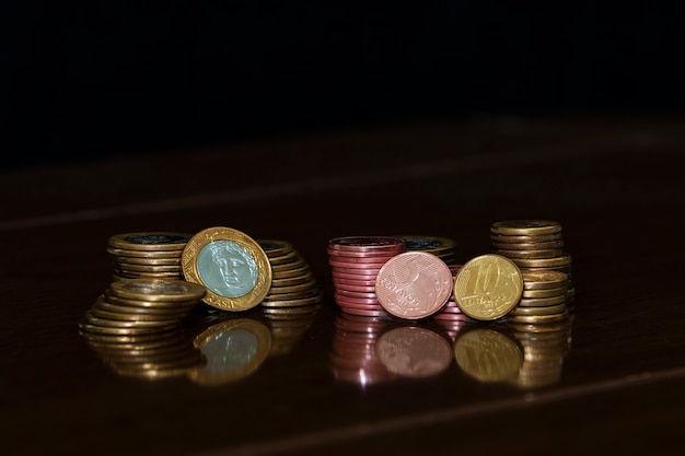 Moedas em moedas brasileiras empilhadas, fundo escuro