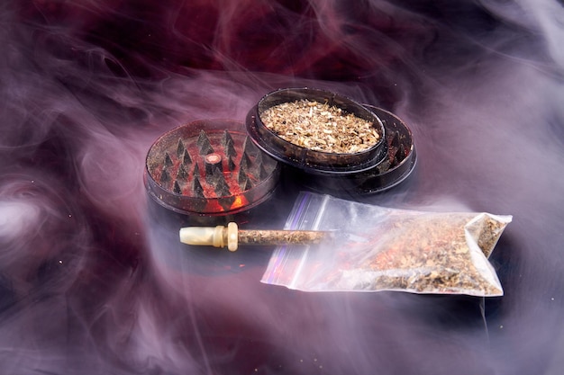 Moedor com tabaco e cachimbo com muita cultura de fumaça de fumar