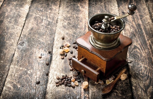 Moedor de café com grãos de café. Sobre um fundo de madeira.