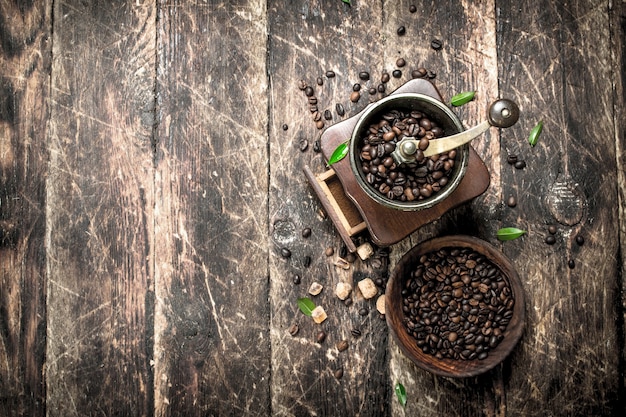 Moedor de café com grãos de café. Sobre um fundo de madeira.