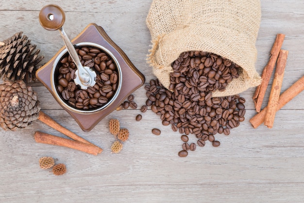 Foto moedor de café e grãos de café derramando fora dos sacos