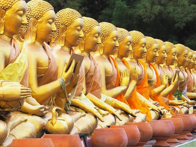 Mönchsstatuen sitzen in verschiedenen Gesten am öffentlichen Tempel