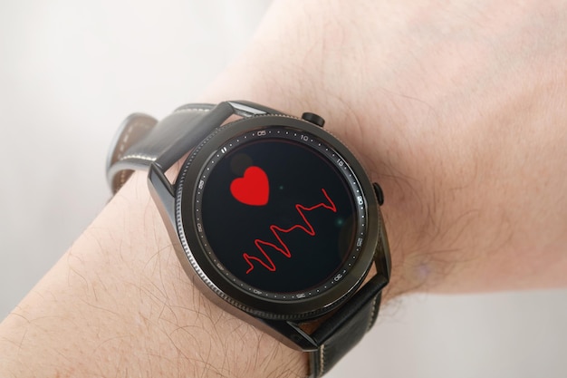 MOGILEV BIELORRUSIA 05 DE ABRIL DE 2023 mano masculina con Samsung galaxy Watch3 Pantalla que muestra la frecuencia cardíaca en la muñeca Día Mundial de la Salud Cerrar