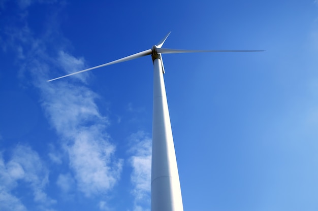 Moinho de vento elétrico visto do chão sobre o céu azul