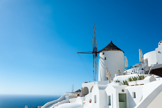 Moinho de vento em Oia com céu azul e mar na ilha de Santorini