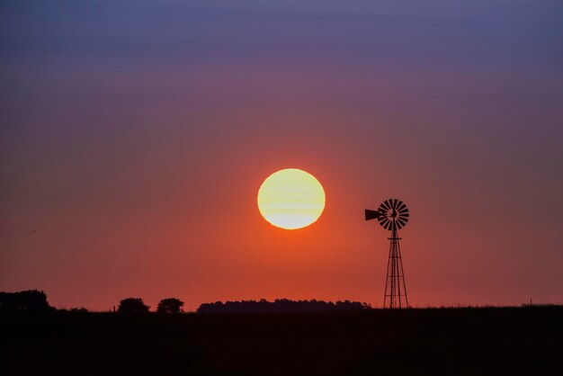 Moinho de vento na zona rural ao pôr do sol Pampas PatagôniaArgentina