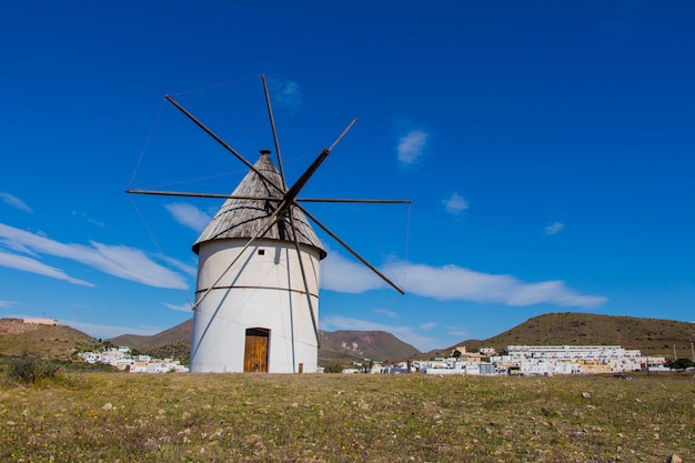 Moinho de vento tradicional e atrás da vila de el pozo de los frailes, moinho de vento tradicional na espanha, pozo de los frailes, província de almeria, moinho de vento sob o céu azul