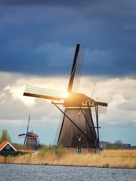 Moinhos de vento contra o céu nublado ao pôr do sol em Kinderdijk Holanda