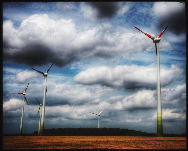 Foto moinhos de vento no campo contra o céu nublado