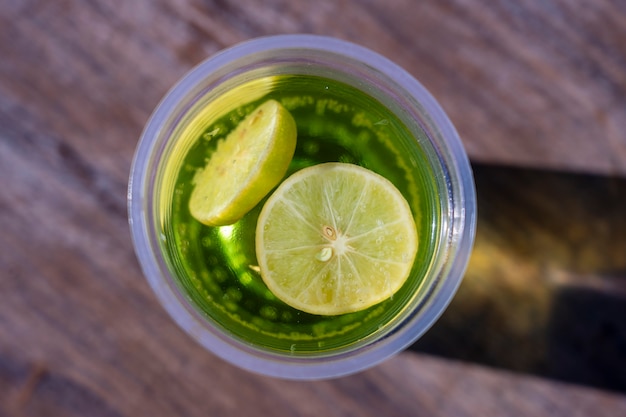 Mojito bebida em um copo de plástico no fundo da mesa de madeira, vista superior, Egito