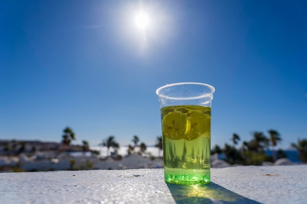 Mojito bebida em um copo de plástico no fundo da praia tropical