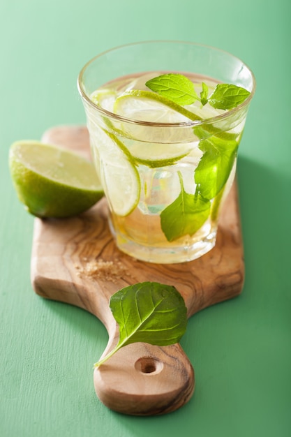 Mojito cocktail e ingredientes sobre fondo verde