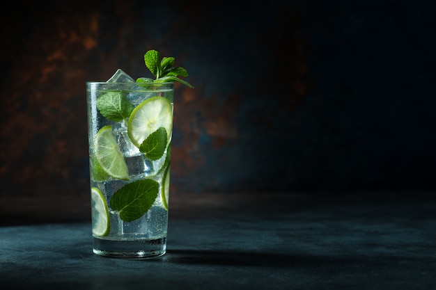 Mojito cocktail em fundo preto com limão e hortelã com espaço de cópia