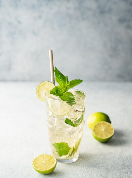 Mojito-Cocktail in einem hohen Glas mit Limettenminze und Eis auf einem leichten Hintergrund