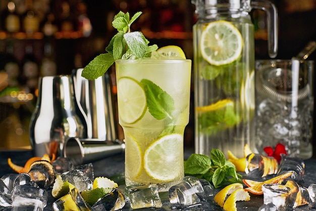 Mojito-Cocktail mit Minze vor dem Hintergrund von Flaschen an der Bar mit Barattributen