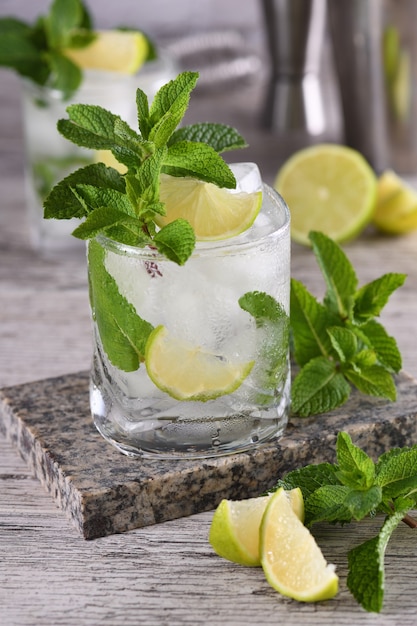 Mojito cóctel alcohólico de verano refrescante con hielo, menta fresca y lima