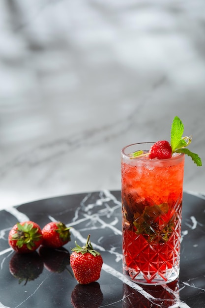 Mojito de morango com folha de hortelã na mesa de mármore. bebidas frescas com morango em fundo claro