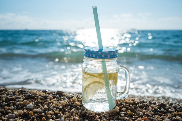 Mojito en frascos de vidrio en la costa del mar. diversión de verano en la playa en el mar