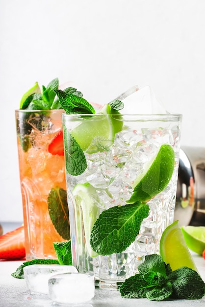 Mojito fresco Mojito conjunto com morango de hortelã limão e gelo em vidro em fundo cinza Bebidas alcoólicas ou não alcoólicas frias bebidas e coquetéis