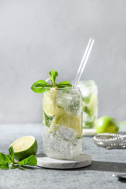 Mojito mit Limettenminze und Eiswürfel auf grauem Hintergrund