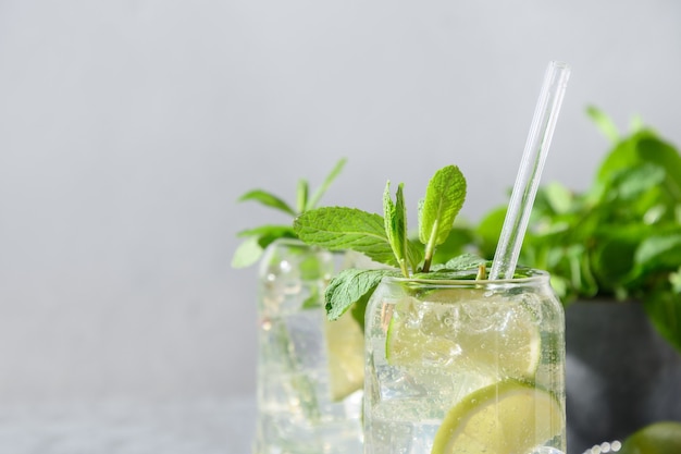 Foto mojito mit limettenminze und eiswürfel auf grauem hintergrund