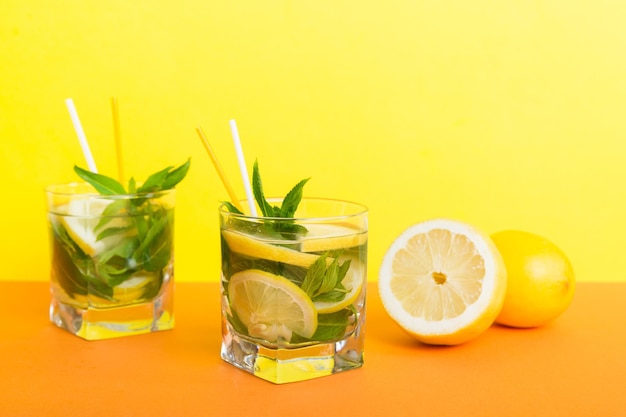 Mojito-Sommer-Erfrischungscocktail mit Eis und Minze Mojito-Cocktail mit Limette, Zitrone und Minze in einem hohen Glas mit einem Stock