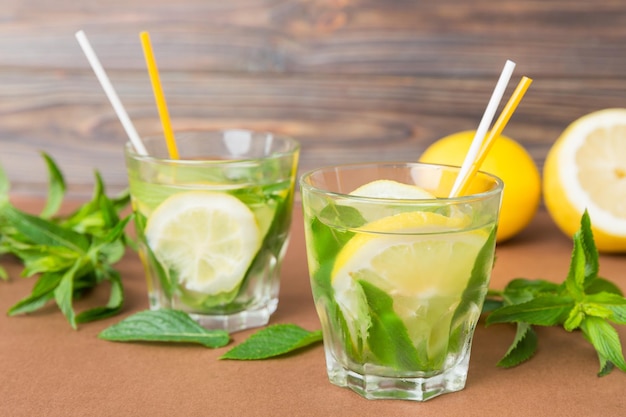 Mojito-Sommer-Erfrischungscocktail mit Eis und Minze Mojito-Cocktail mit Limette, Zitrone und Minze in einem hohen Glas mit einem Stock