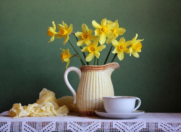 Mola ainda vida com um buquê de narcisos amarelos no vaso e uma velha caneca.