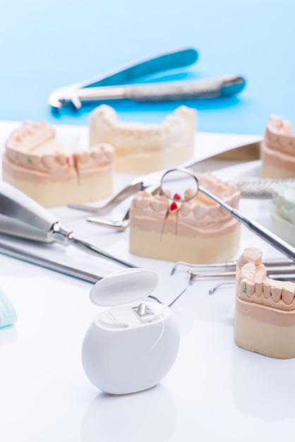 Molde de dientes y herramientas dentales básicas en mesa blanca
