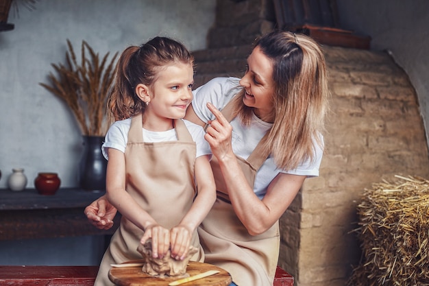 Molde de madre e hija con arcilla disfrutando del arte de la cerámica y pro