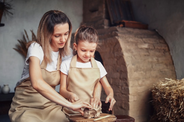 Molde de madre e hija con arcilla disfrutando del arte de la cerámica y pro